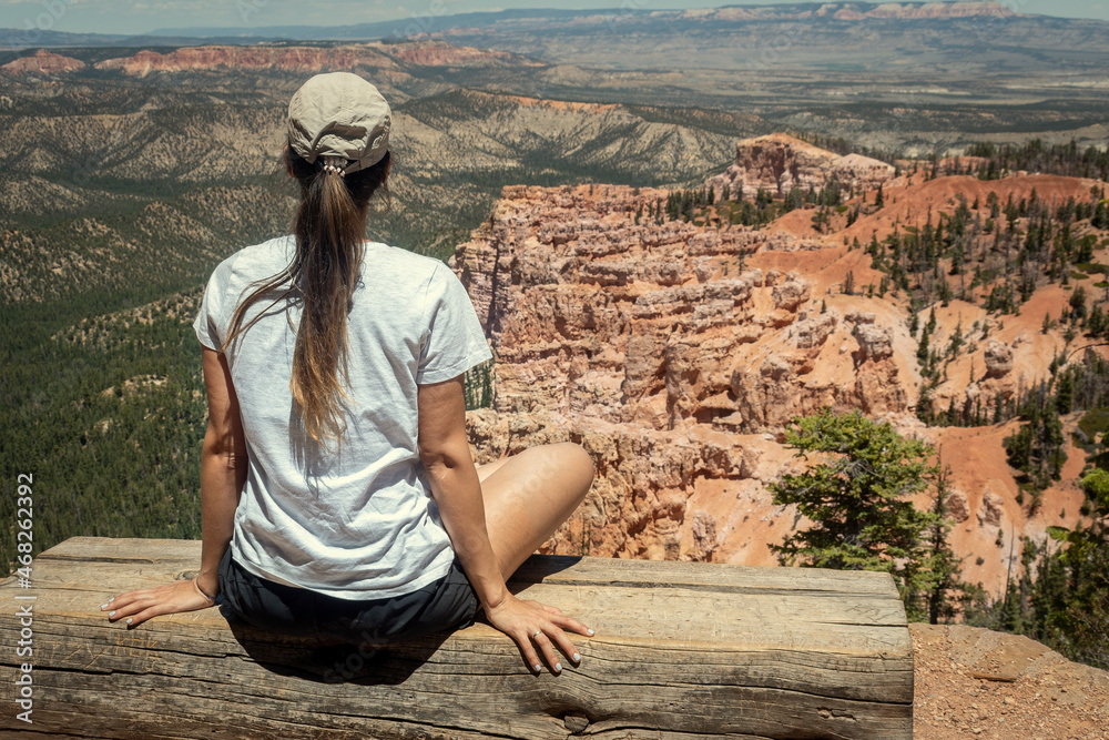 Girl meditating while looking and contemplating a beautiful landscape in a National Park in Utah