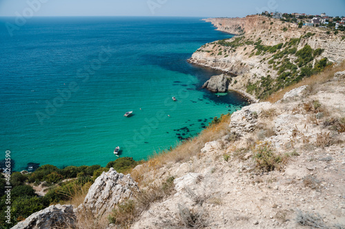 Boats and yachts in the crystal clear azure sea on a sunny day. Cape Fiolent in Sevastopol. The concept of an ideal place for summer travel and relaxation © Igor Tichonow
