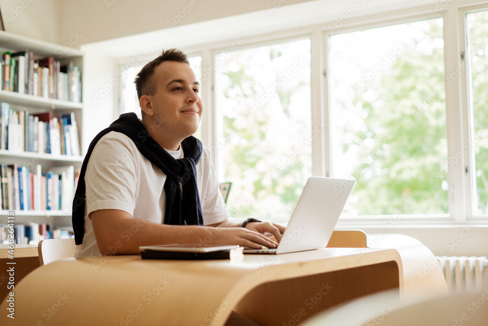Male online education via the Internet on the school's website. A student in class at the Institute. College break. Surfing on a laptop. Male online education via the Internet on the school's website. A student in class at the Institute. College break. Surfing on a laptop.