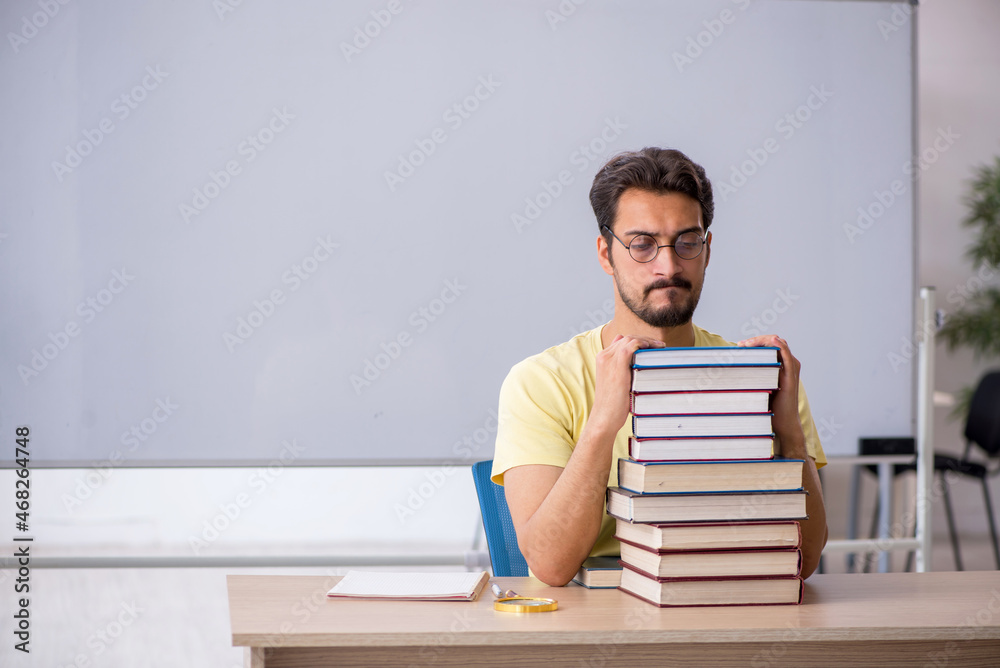 Young male student preparing for exams in the classroom