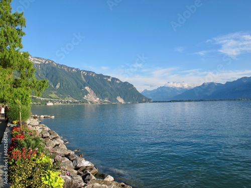 Lake in Italy during spring with blooming flowers and green trees on the shore