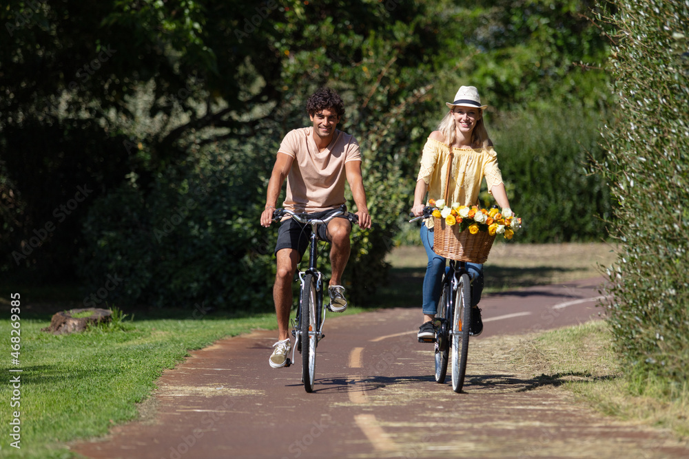 young couple is cycling in the forest