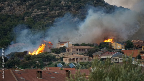 Incendio en la montaña entre casas, cenicientos