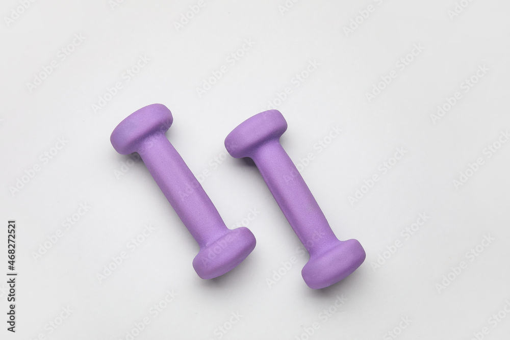 Purple dumbbells on light background Purple dumbbells on light background