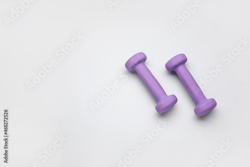 Purple dumbbells on light background © Pixel-Shot