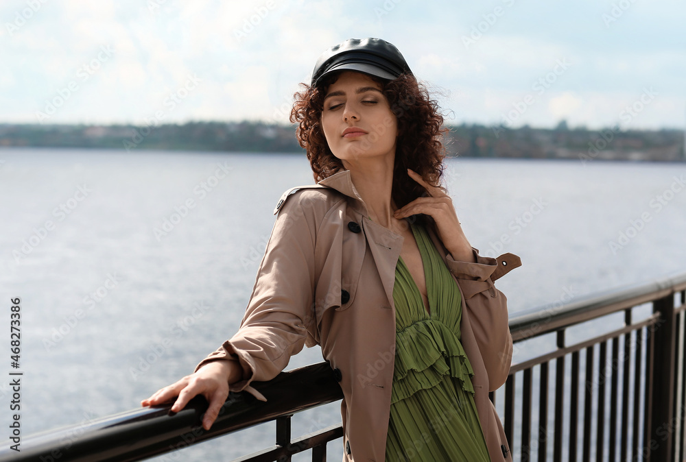 Young woman in leather cap enjoining sunny day outdoors Young woman in leather cap enjoining sunny day outdoors