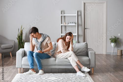 Obraz na plátně Upset young couple after quarrel sitting on sofa at home