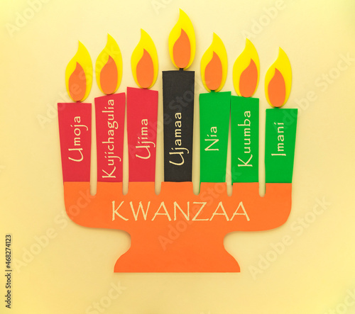 Happy Kwanzaa Greeting Card Background. Candleholder made from paper with Kwanzaa Principles in Swahili - Unity, Self-Determination, Ujima, Cooperative Economics, Purpose, Creativity, Faith
