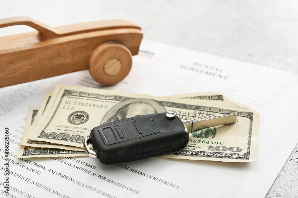 Rental agreement, money, key and wooden car, closeup Rental agreement, money, key and wooden car, closeup