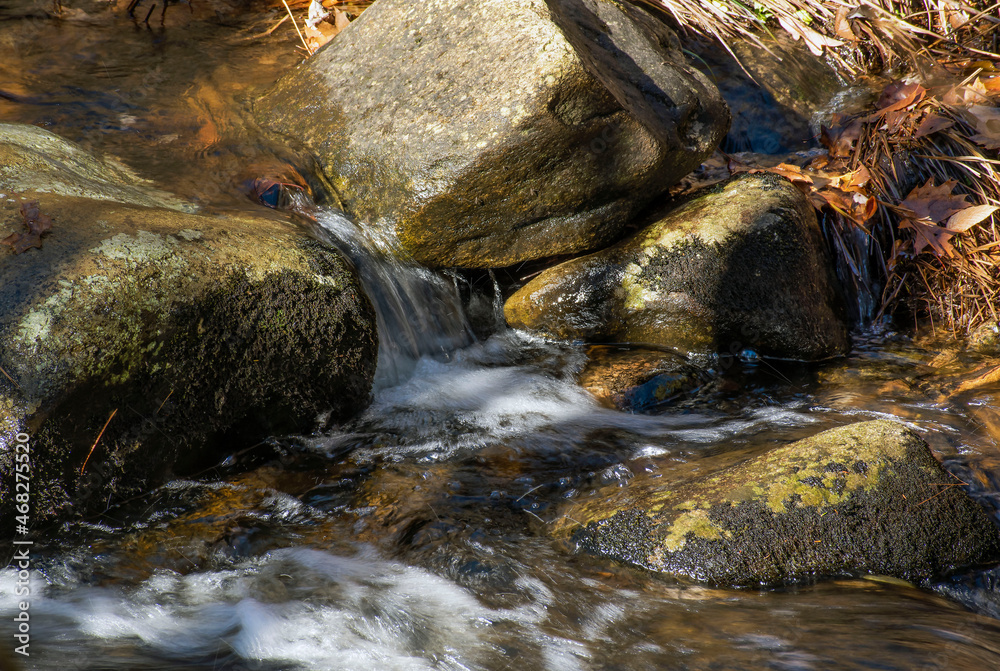 water cascading between rocks in a small brook in new england water cascading between rocks in a small brook in new england