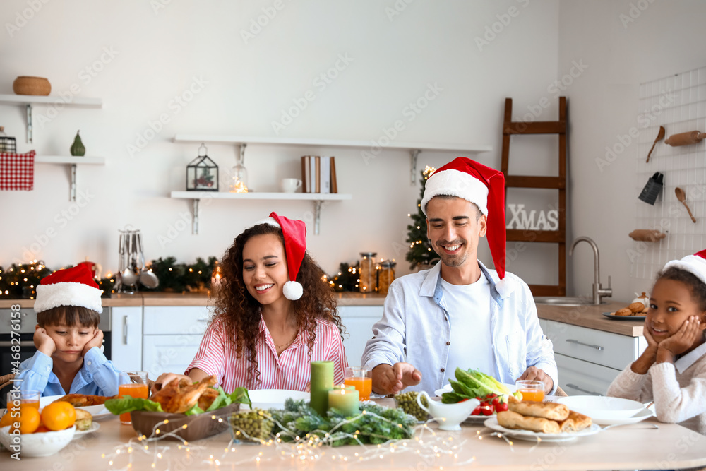 Happy family having Christmas dinner in kitchen Happy family having Christmas dinner in kitchen