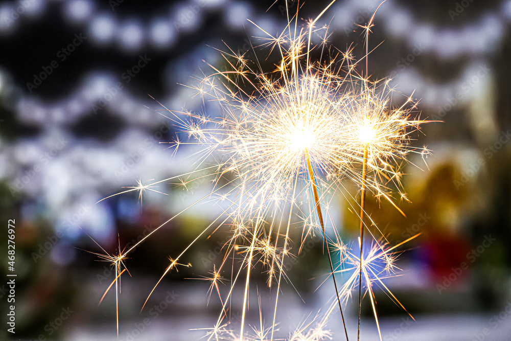 Naklejka premium Beautiful burning sparklers at night city