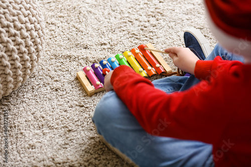 Little boy playing xylophone at home on Christmas eve