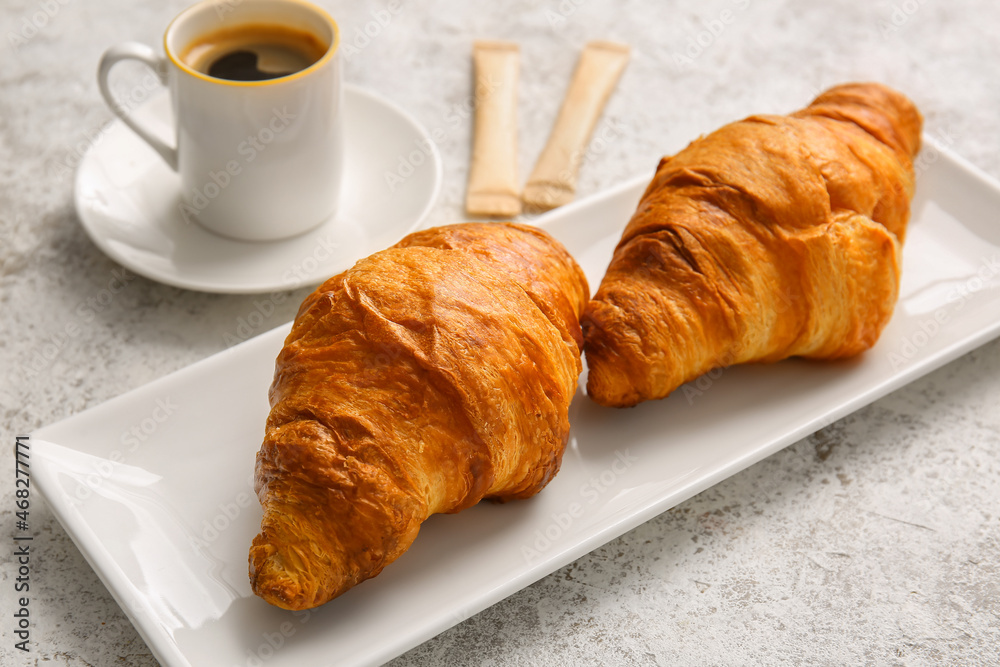 Plate with delicious croissants on light background Plate with delicious croissants on light background