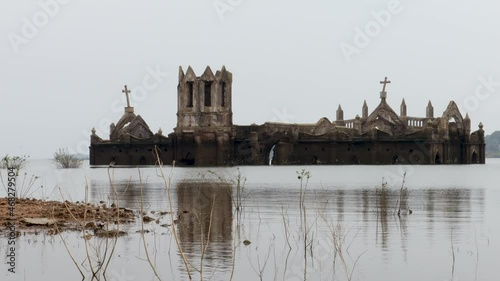 A Dramatic view of an ancient Catholic Church seen immersed in backwaters at Shetty halli village in Hassan, a famous tourist destination in Karnataka, India. photo