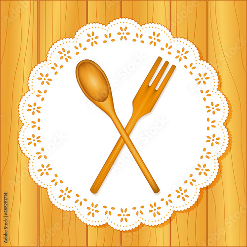 Wooden kitchen tools, spoon and fork, lace doily place mat, oak wood table background photo