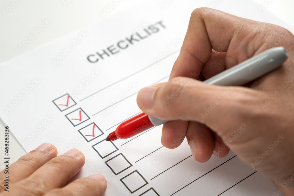 Hand with red marker pen marking on checklist sheet Stock Photo Adobe