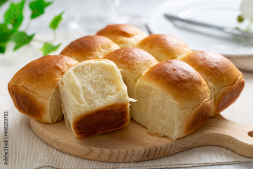 Photos Freshly baked golden brown dinner rolls bread served on wooden board