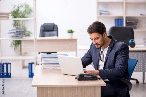 Young handsome employee working in the office