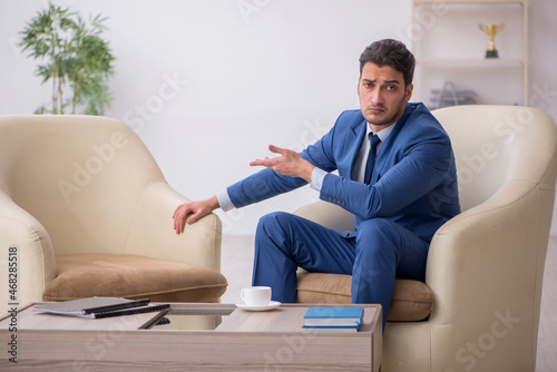 Young male employee waiting for business meeting