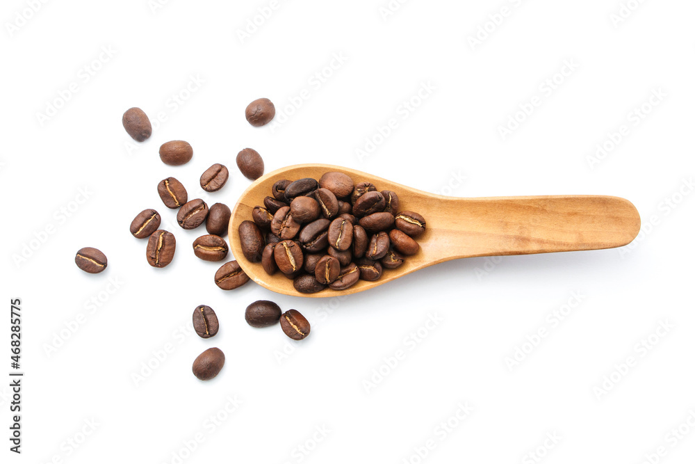 Obraz premium Roast coffee beans in wooden spoon isolated on white background.