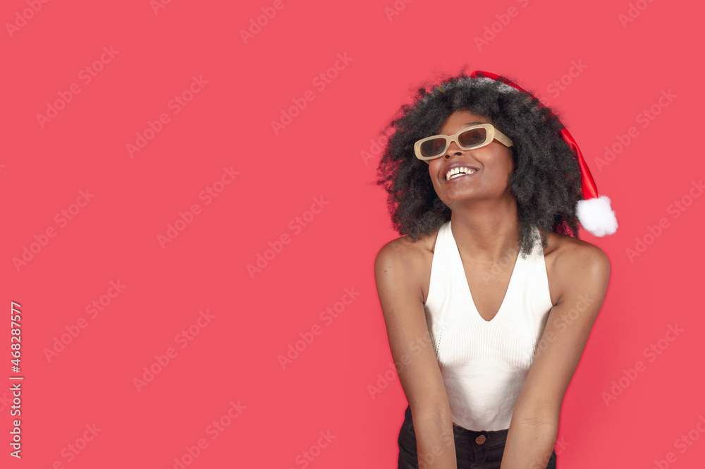 young brunette afro girl, wearing christmas hat happy for the beginning of christmas with copy space left wing young brunette afro girl, wearing christmas hat happy for the beginning of christmas with copy space left wing