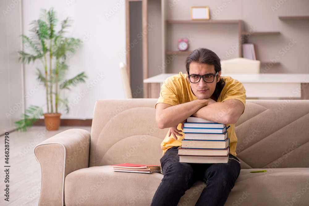 Young male student preparing for exams at home