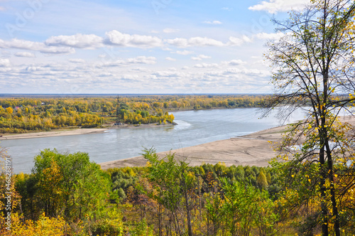 View from the mountain to the river through the autumn trees