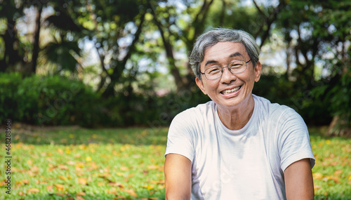 Portrait of healthy happy senior asian old man in the park outdoors exercise stretching his arms. Spring healthcare lifestyle grandfather retirement wellness healthy, Chinese old men concept photo