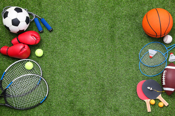 Different sport equipment on green grass, flat lay. Space for text