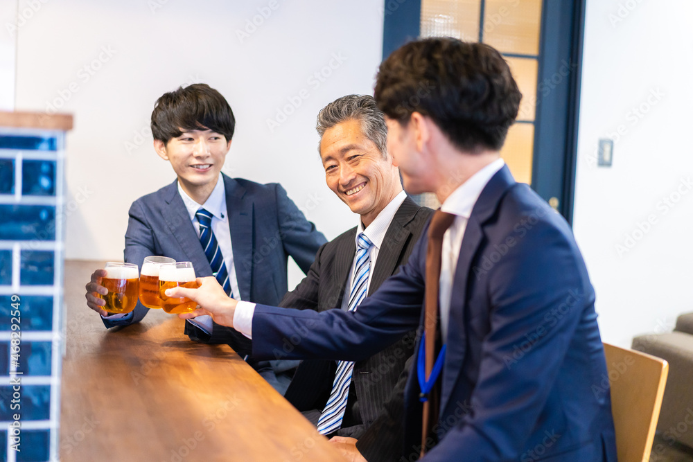バーで乾杯をする3人の会社員