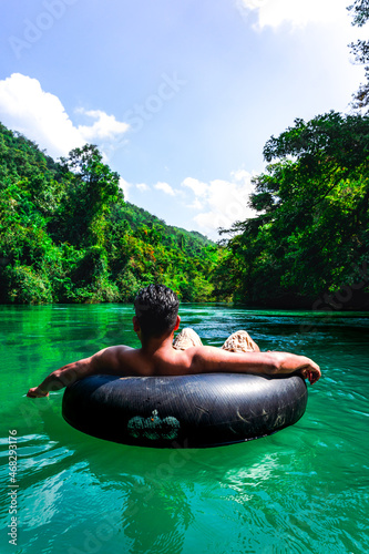 Vászonkép Person tubing in the river