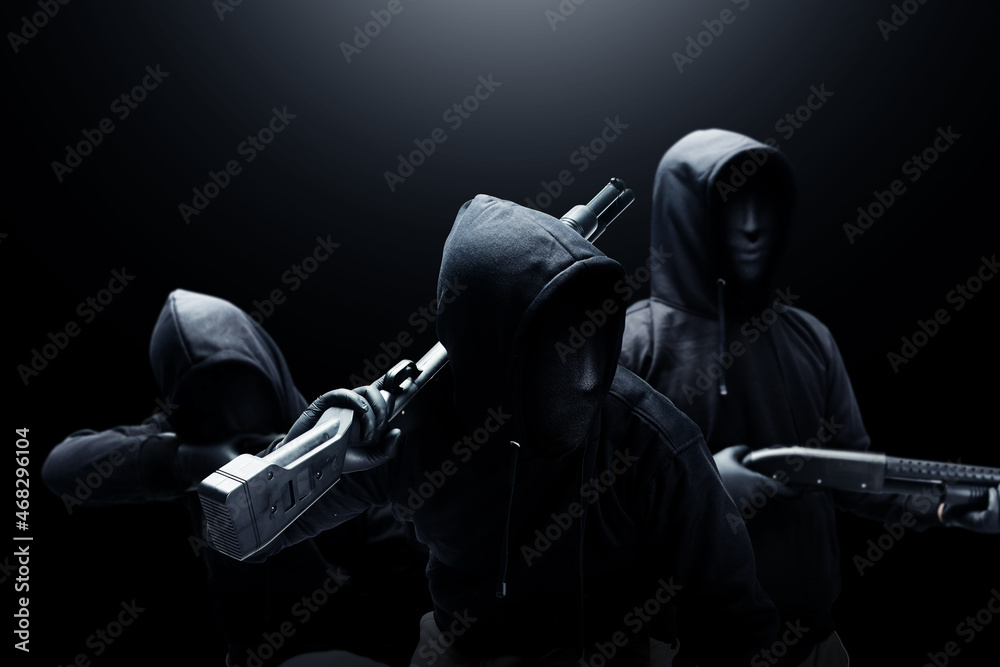 Group of criminal man in a hidden mask with a shotgun