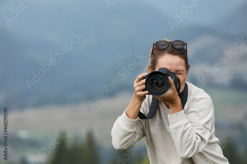 Photographer working with modern professional camera outdoors