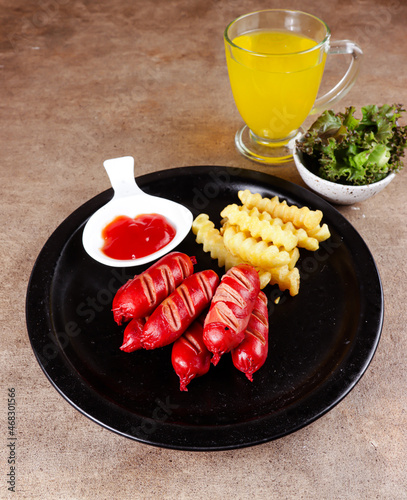 Sosis bakar. Grilled sausage with french fries and sauce. photo