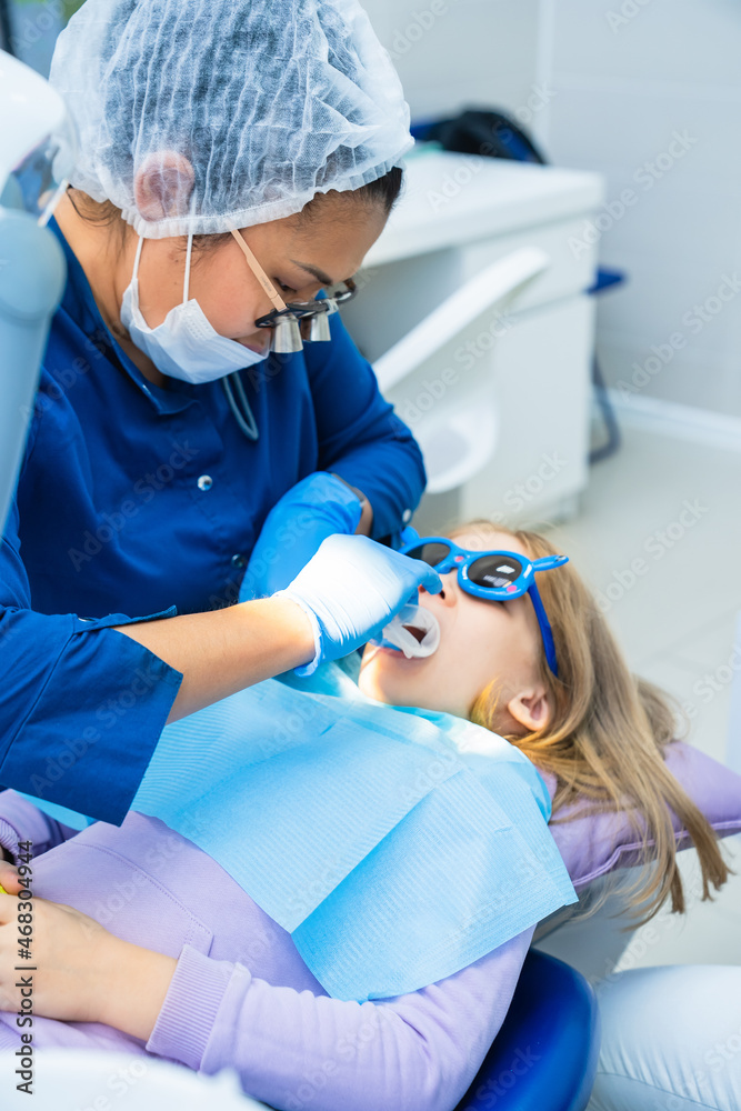 kid girl with oral dilator at dentist's appointment. treatment of teeth kid girl with oral dilator at dentist's appointment. treatment of teeth