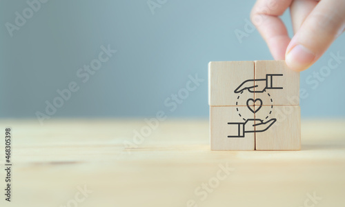 Customer relationship management (CRM) or customer loyalty concept. Customer satisfaction, retention strategies. CRM or customer loyalty program banner. Hand put wooden cubes with holding heart icon. photo