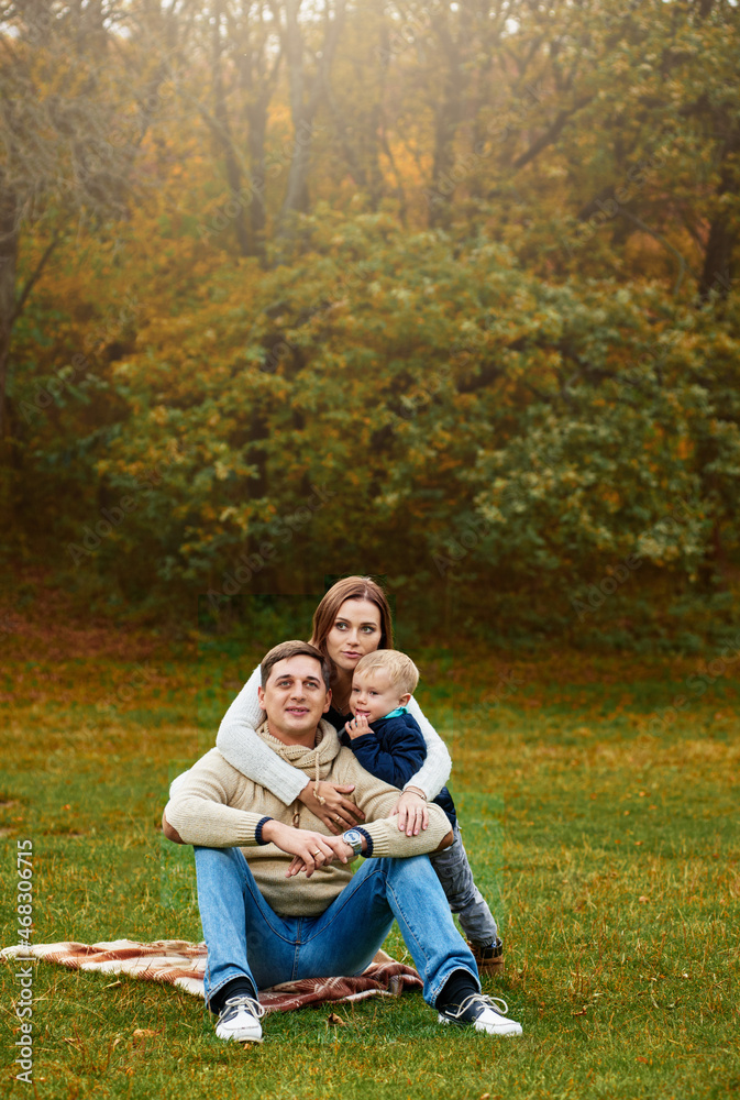 boy and mother hugging father during stroll in autumn park