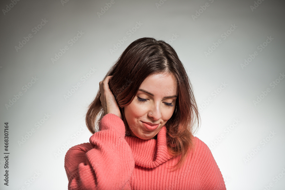 young shy woman portrait in pink sweater on studio background young shy woman portrait in pink sweater on studio background
