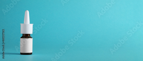 Bottle of nasal spray on light blue background, space for text