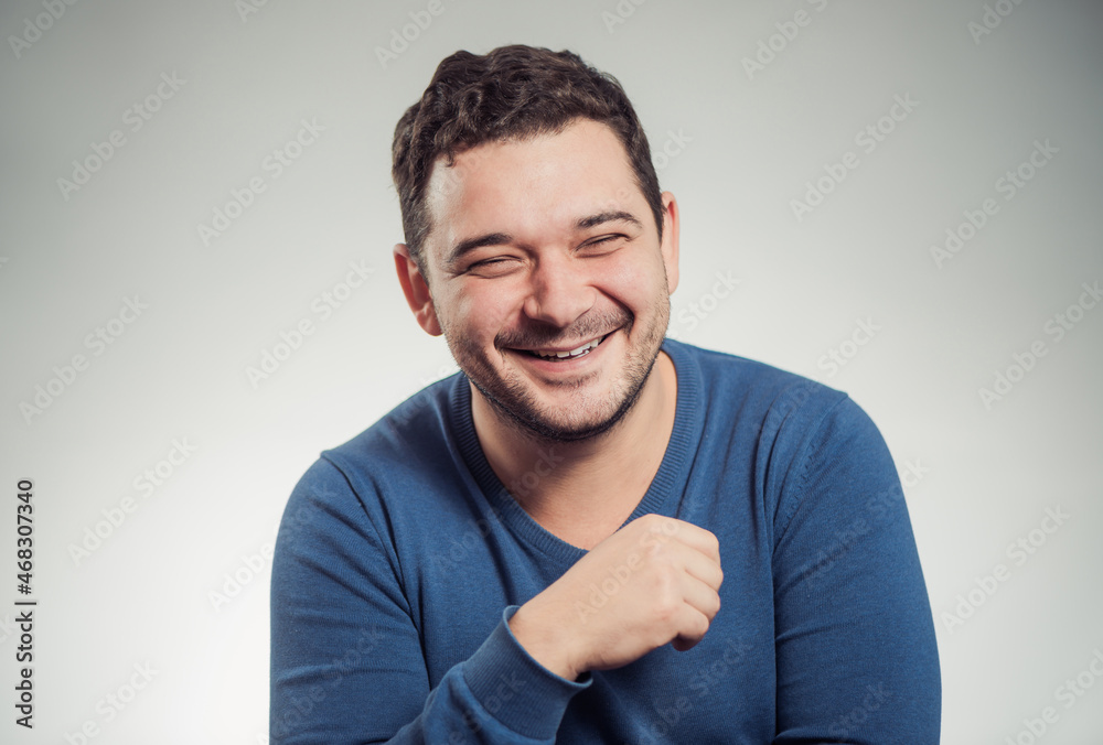 young laughing man portrait in blue sweater at studio background young laughing man portrait in blue sweater at studio background