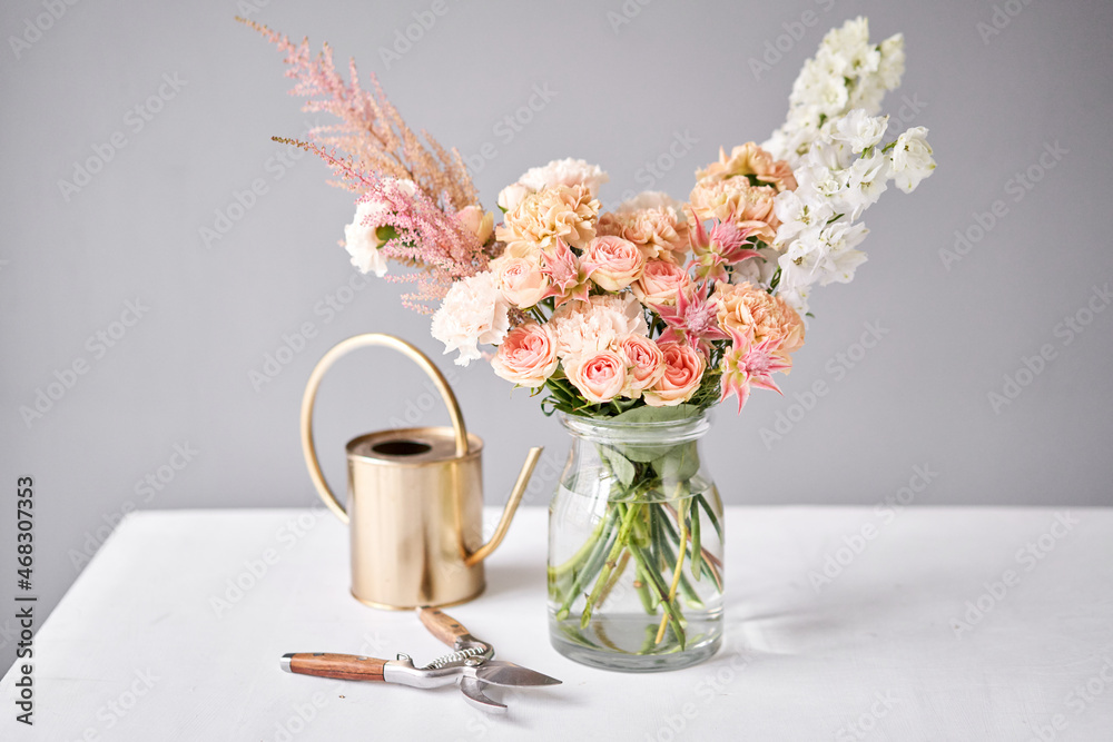 Fototapeta premium Finished flower arrangement in a vase for home. Flowers bunch, set for interior. Fresh cut flowers for decoration home. European floral shop. Delivery fresh cut flower.