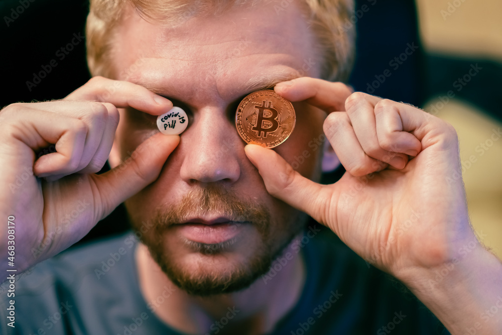 Fototapeta premium Man with a new COVID-19 pill and bitcoin. A new life in the modern world