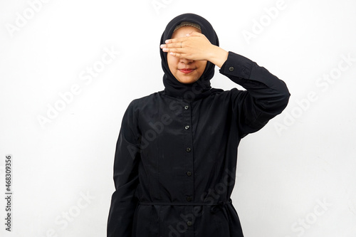 Beautiful young asian muslim woman with hands closing eyes, isolated on white background