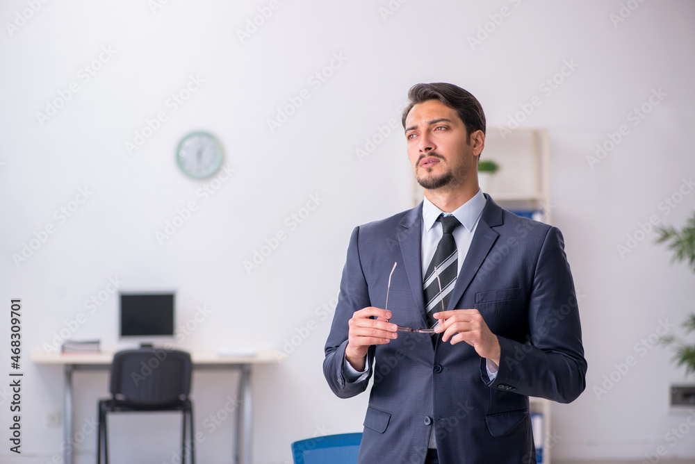 Young male employee sitting at workplace Young male employee sitting at workplace