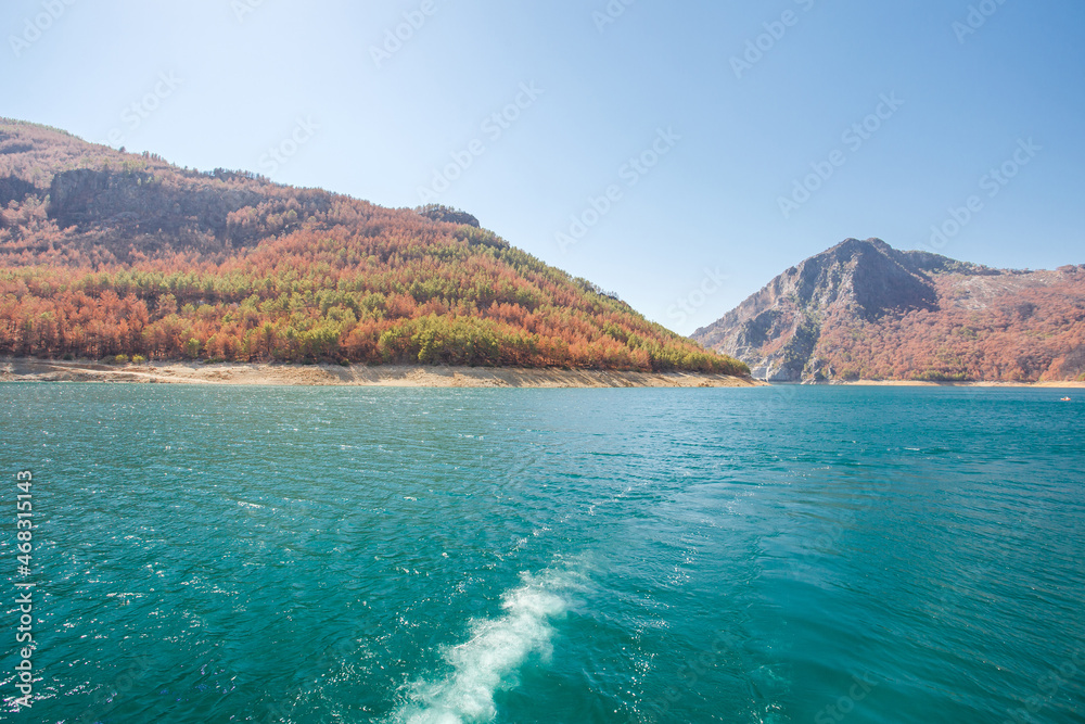 Surface of water in pond with blue water and mountains with rocks, wake jet. Surface of water in pond with blue water and mountains with rocks, wake jet.