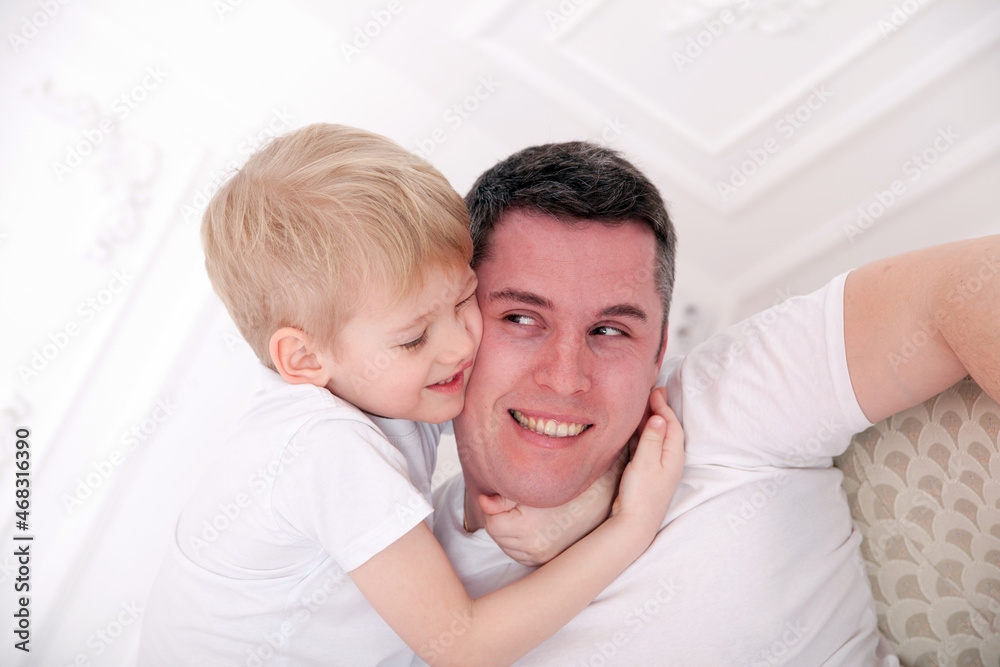 Happy father and son in bright home interior. Happy father and son in bright home interior.