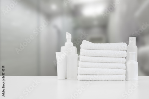 Spa still life with towels and skincare cosmetics against blurred background