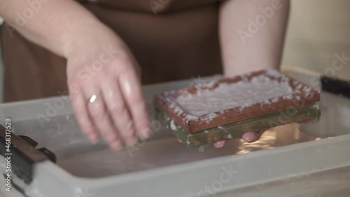 A woman holding a frame for making paper sheets from recycled paper. Selective focus. Household hobby, paper recycling. The concept of zero waste, recycling, ecology