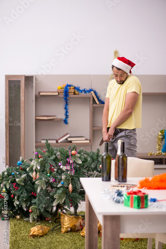 Young man cleaning the apartment after Christmas party